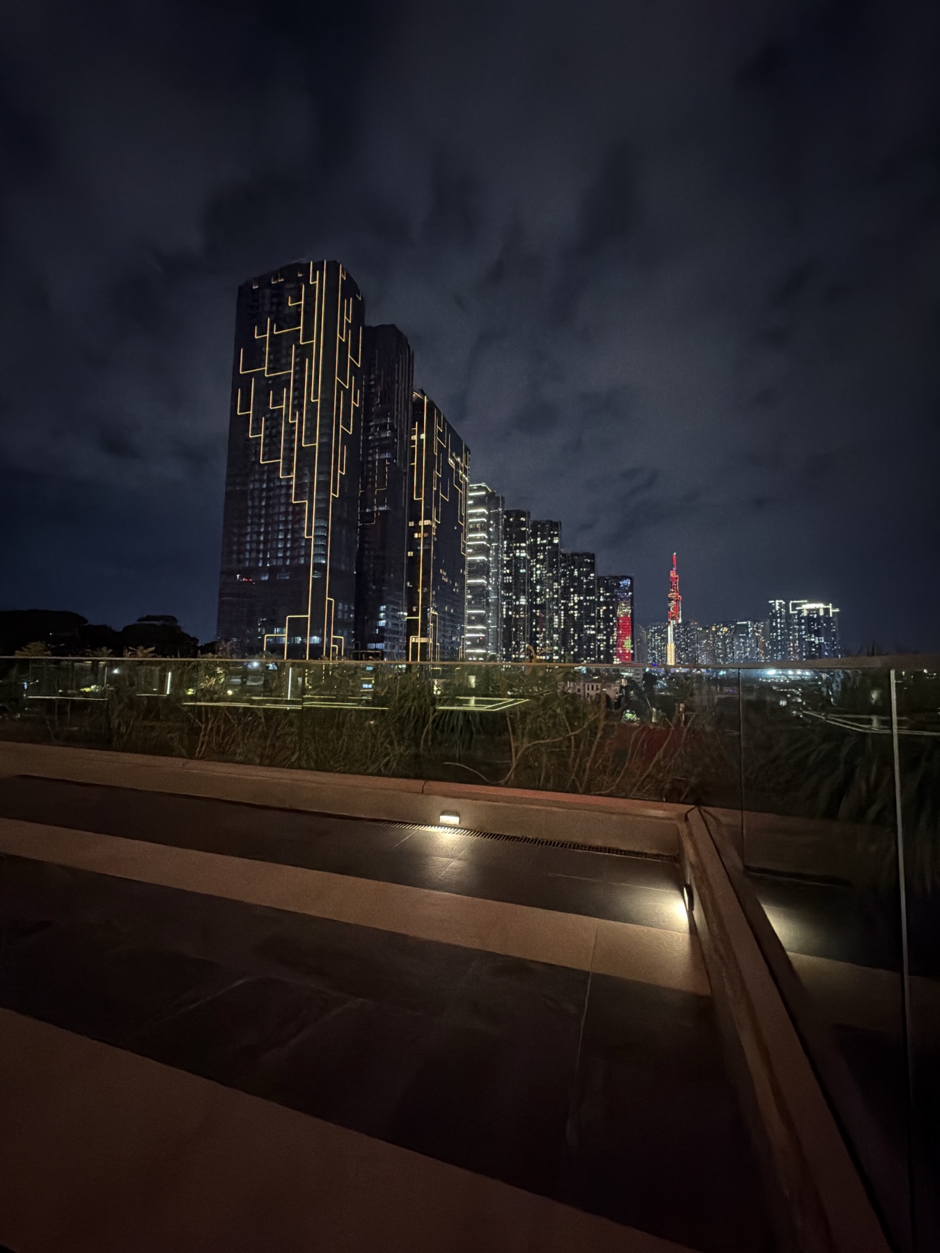 Night skyline seen from the landscaped terrace beside Grand Marina Saigon
